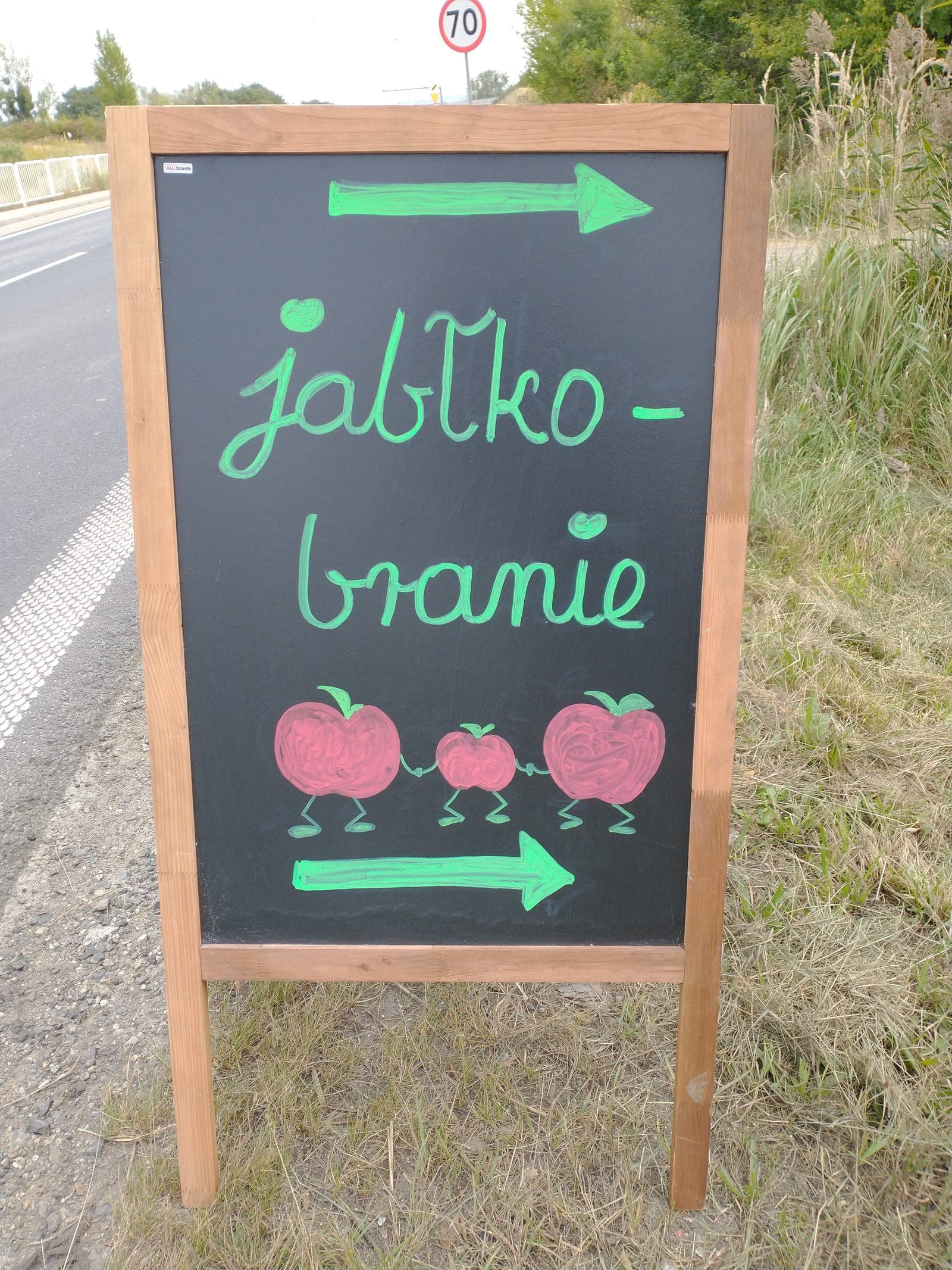 Kredowa tablica Jabłkobranie z jabłuszkami wskazująca drogę do sadu